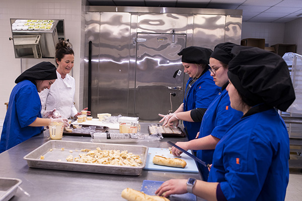 students and an instructor working in a kitchen