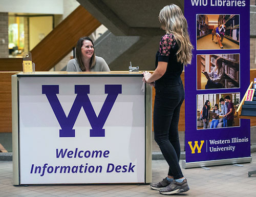 student at the library information desk