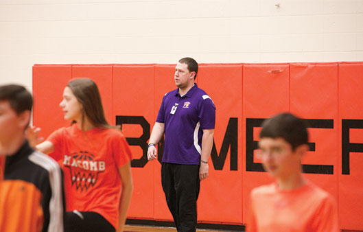 A PE teacher in the gym with two students