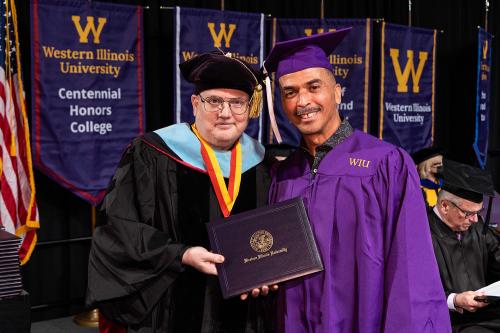 Libraries Professor Michael Lorenzen, left, presents Brian Tucker with his Bachelor of General Studies degree during the fall commencement ceremony in December. 