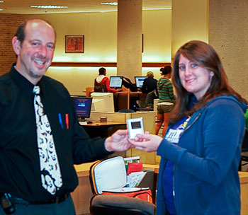 Image of Librarian Brian Clark presenting Mary with her new iPod Nano.