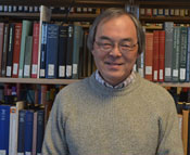 Photo of Dr. Felix Chu in front of a bookshelf.