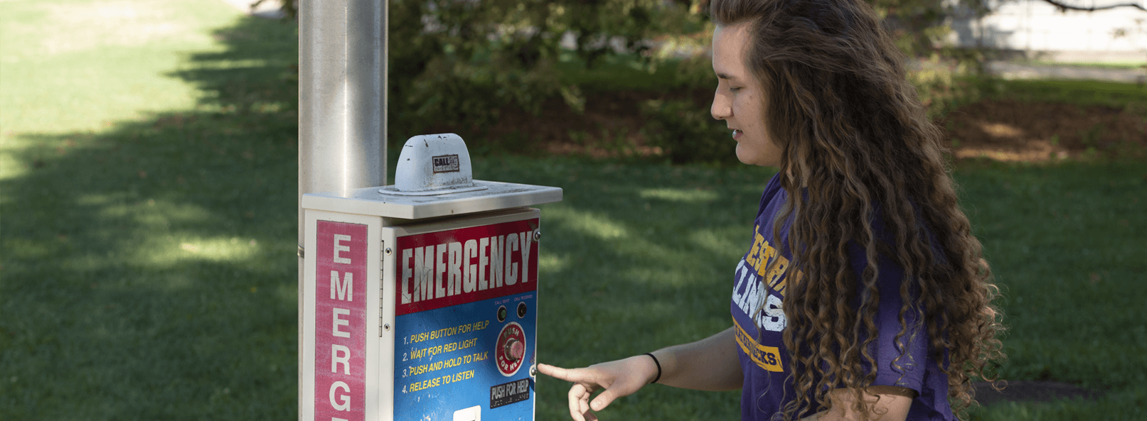 A student infront of an emergency call box.