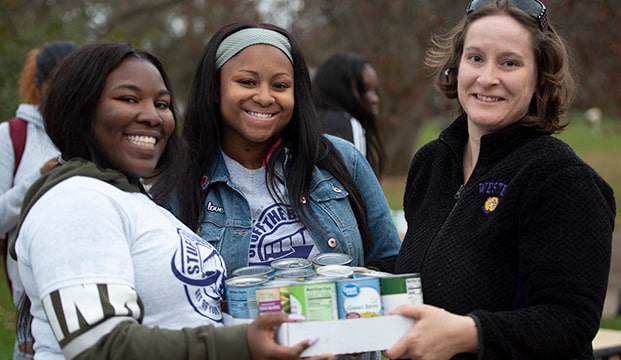 a group of students distributing canned food