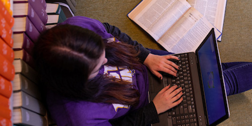 student in the library using a computer