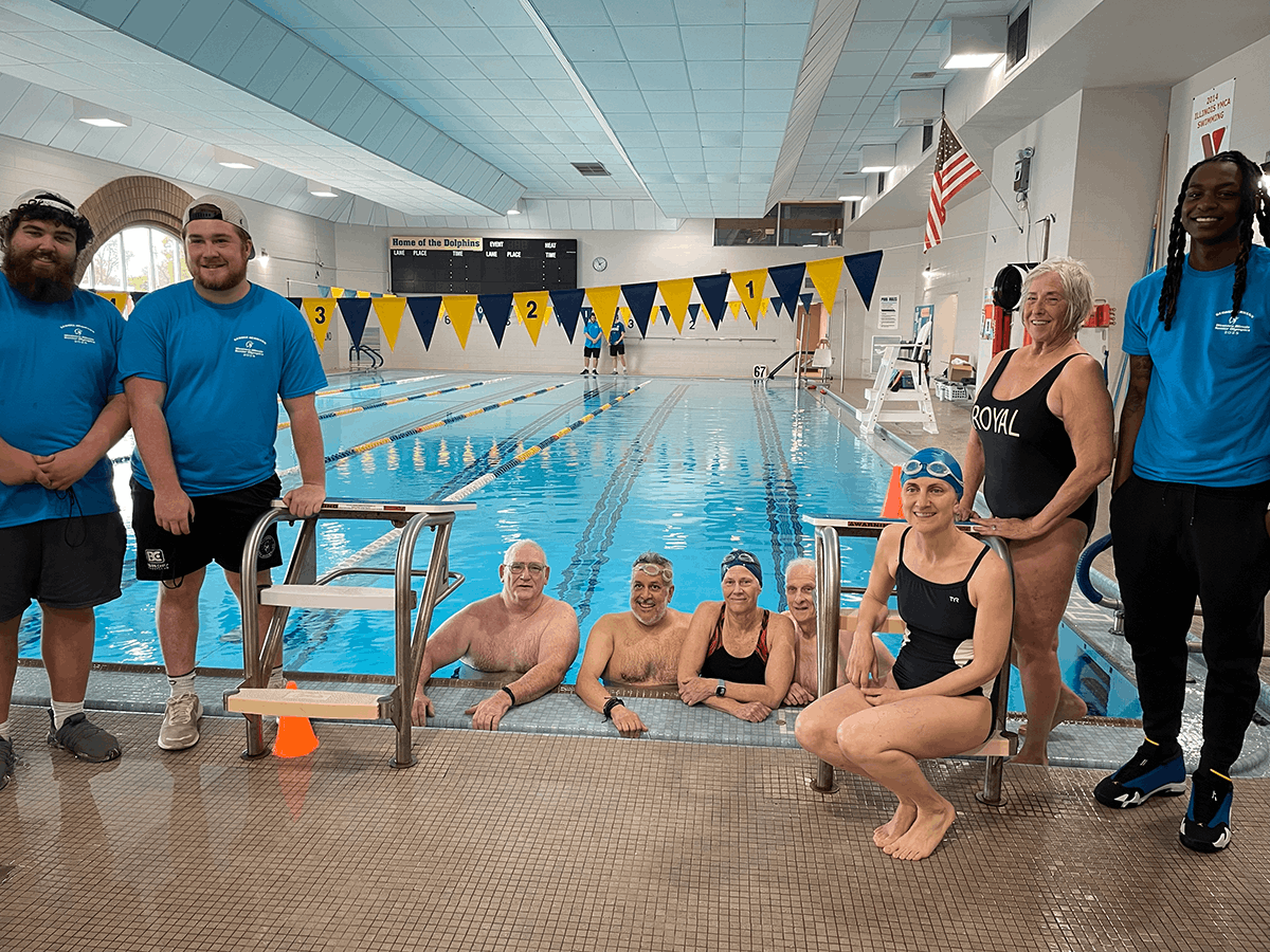 Nine people around a swimming pool