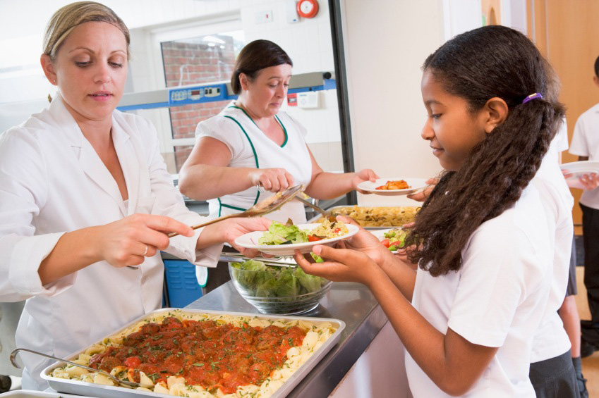 lunchroom workers serving food to kids