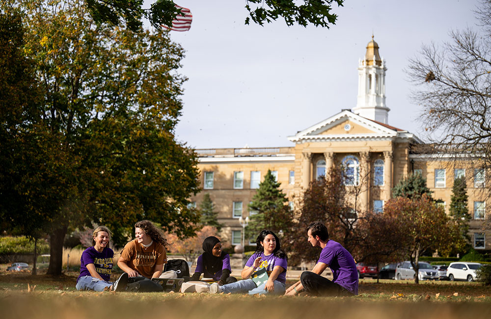 photo of students sitting on lawn in front of Sherman Hall