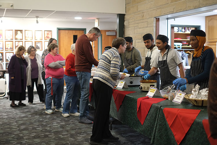 attendees filling their plates with Bangledeshi food