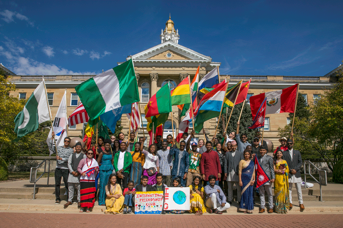 group in front of sherman hall with flags