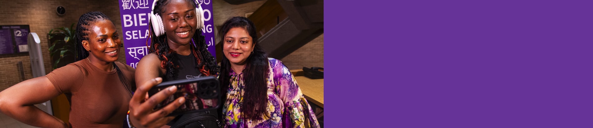 three students in the library taking a selfie