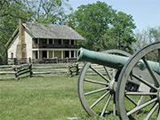 Photo of a house with a cannon in front of it.