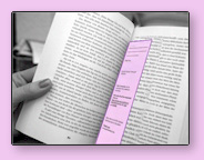image of a hand holding a book with a purple bookmark