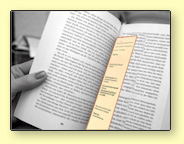 image of a hand holding a book with a yellow bookmark