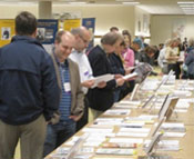 Photograph of people looking at publications from the 2012 WIU Author Recognition Reception.