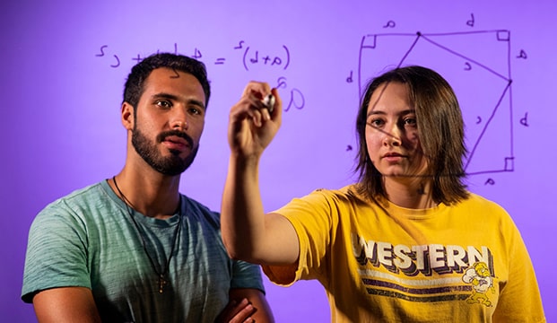 two students doing geometry equations on a clear whiteboard