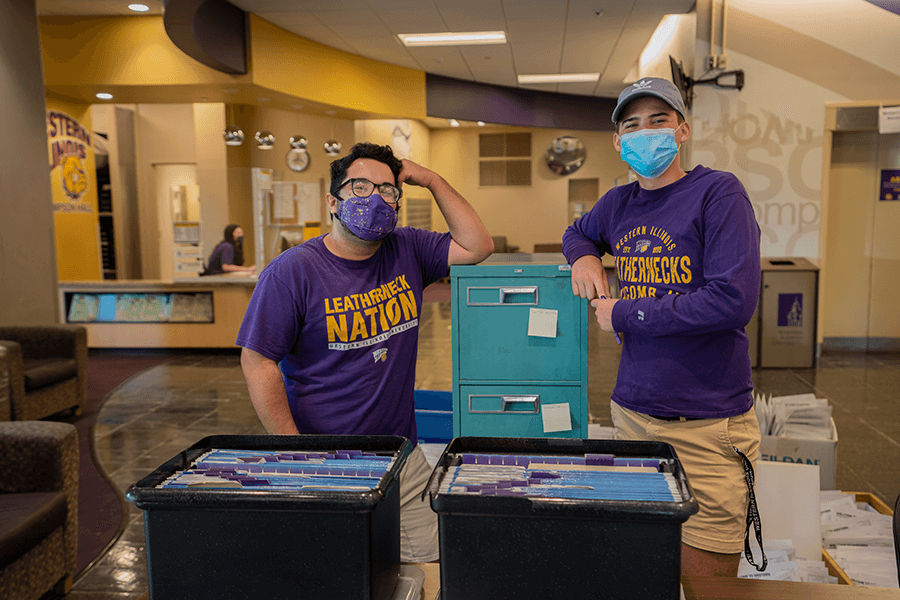 Photo of two move in crew members by filing cabinet