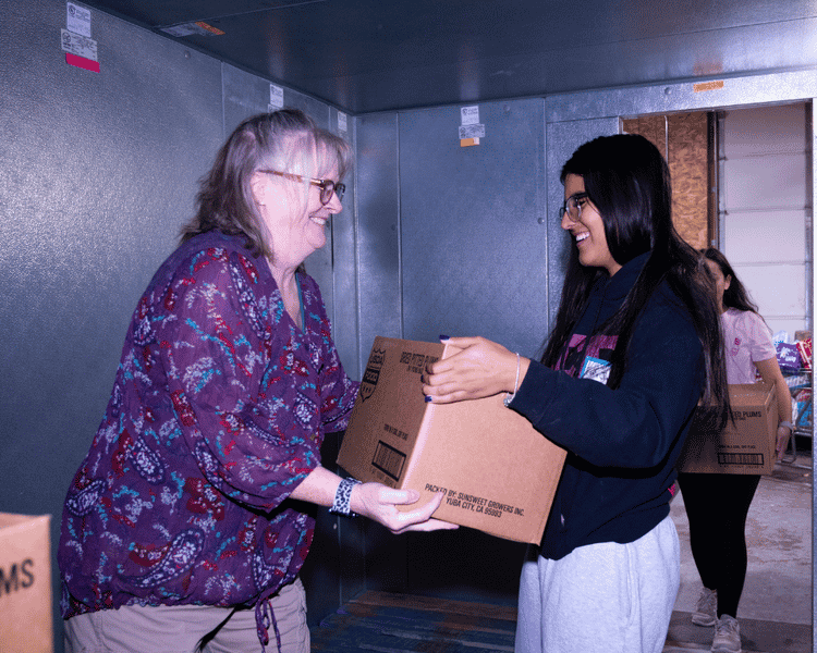 one person handing a box to another.