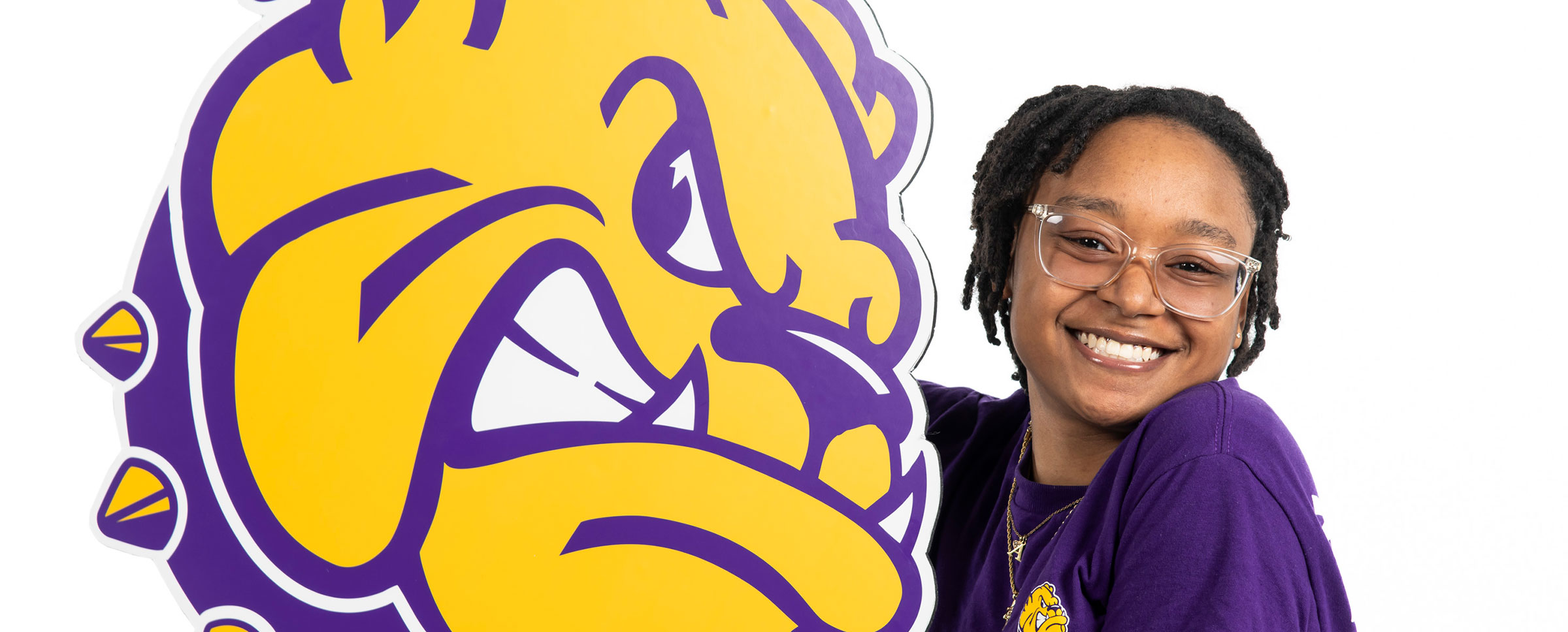 female student smiling while holding large printed rocky head logo