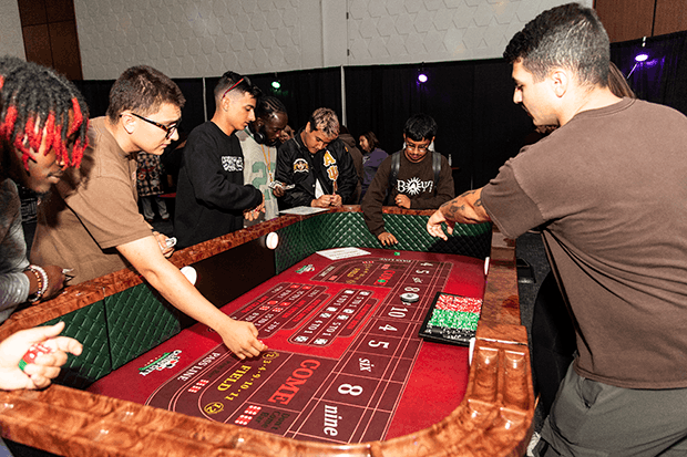 People gathered around a craps table at a gaming event.